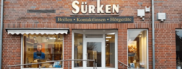 Fassade eines Optiker-Fachgeschäfts mit Schaufenstern für Brillen und Hörgeräte.